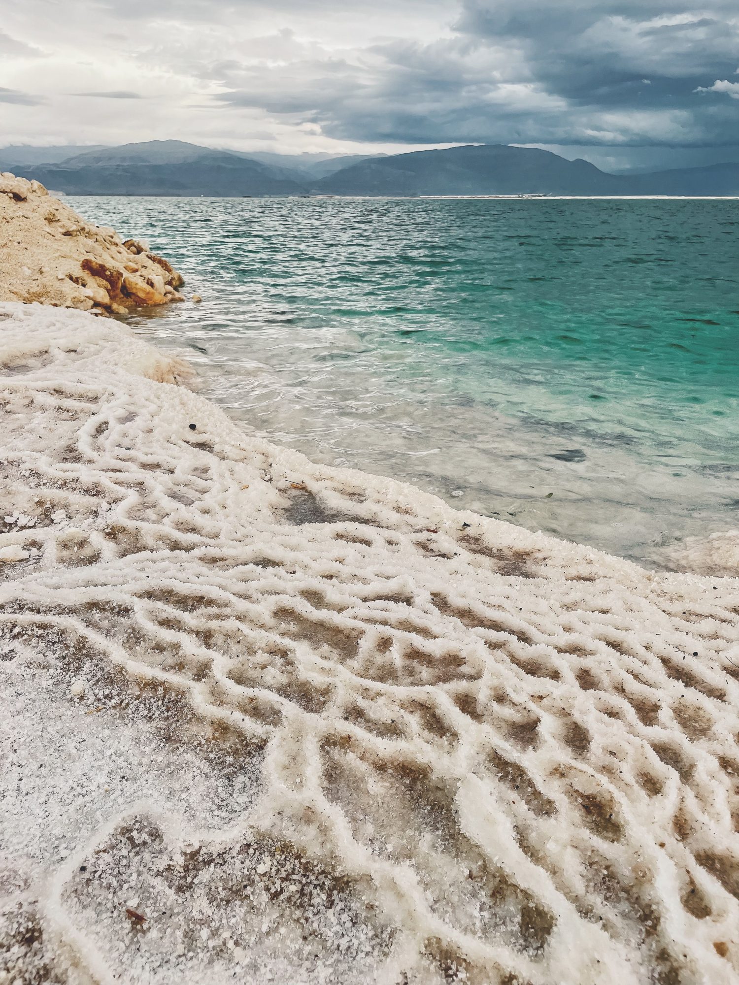 Salt crust along a turquoise shoreline